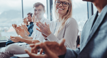 corporate group attending a networking event clapping and smiling